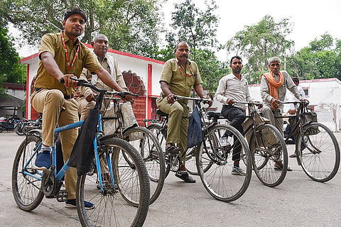 Postmen pedal through the city to deliver mail on World Bicycle Day, in Prayagraj.