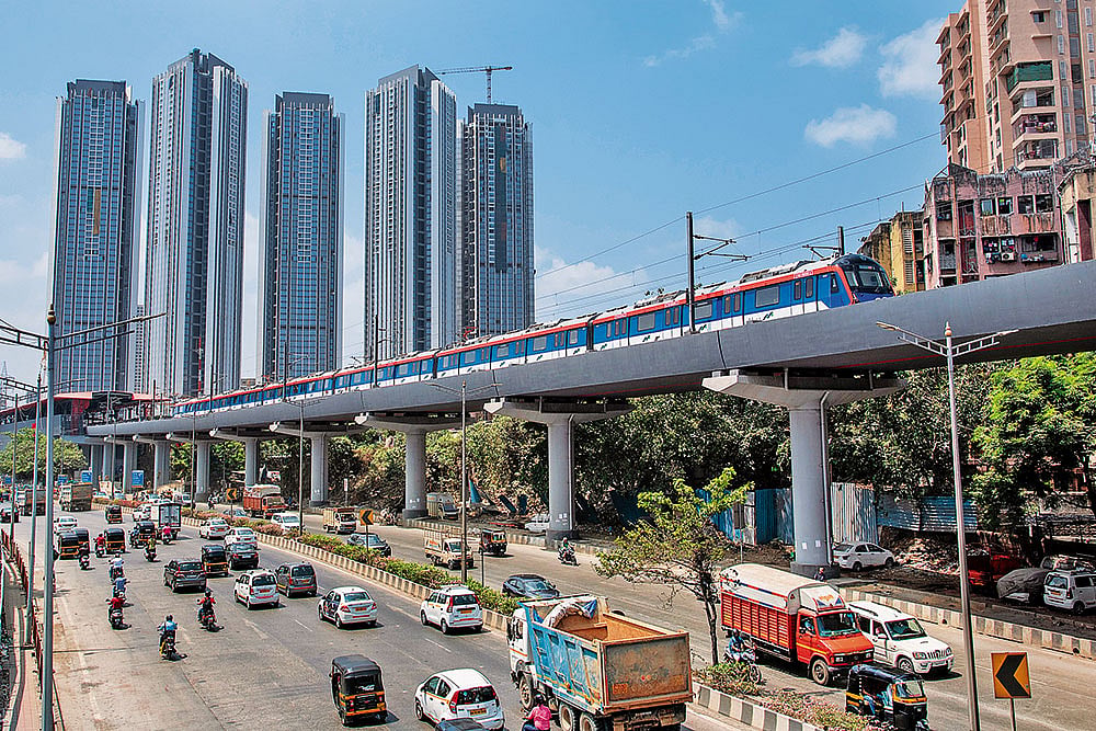 A metro passes by while vehicles move on the Western Express Highway in Mumbai