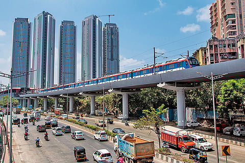 The Peak Time: A metro passes by while vehicles move on the Western Express Highway in Mumbai
