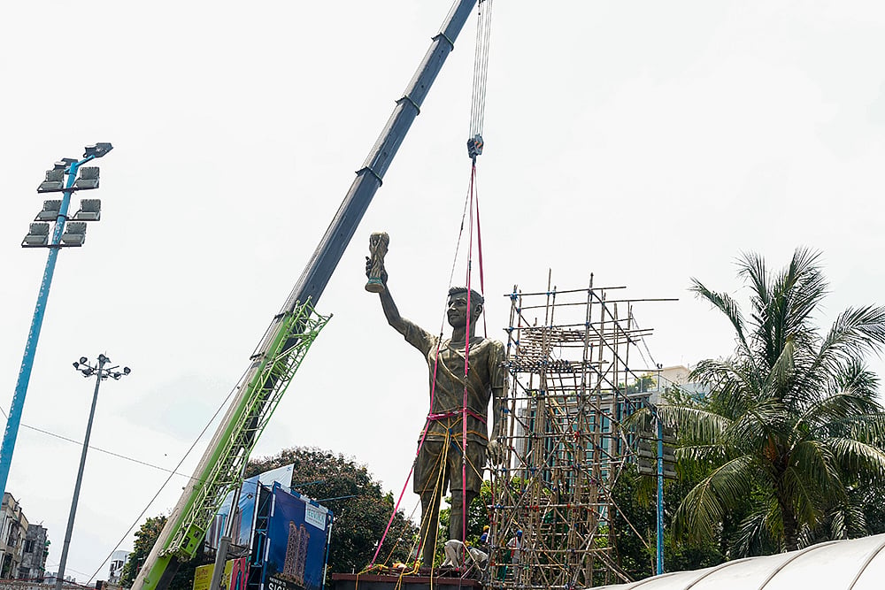 PWD workers use a crane to remove a statue of Argentine footballer Lionel Messi, in Kolkata. - | Photo: PTI/Swapan Mahapatra
