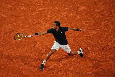 Canada's Felix Auger-Aliassime returns to Italy's Flavio Cobolli during the quarterfinal tennis match at the French Open in Paris.