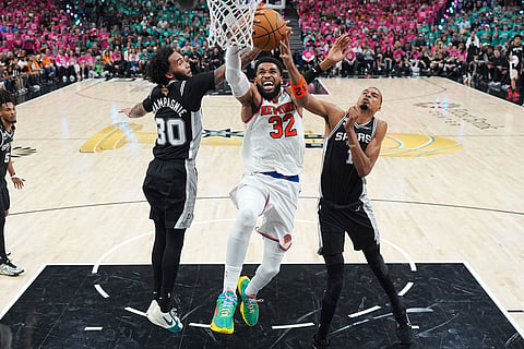 New York Knicks center Karl-Anthony Towns (32) shoots between San Antonio Spurs forward Victor Wembanyama (1) and forward Julian Champagnie (30) during the first half of Game 1 of the NBA Finals basketball series in San Antonio.