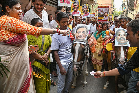 BJP leader Priyanka Tibrewal, left, and others protest against rebel MLA Sandeepan Saha, who has been expelled from the TMC, and his father and former TMC MLA Swarna Kamal Saha, accusing both of land grabbing and extortion, in front of Saha's house, in Kolkata.