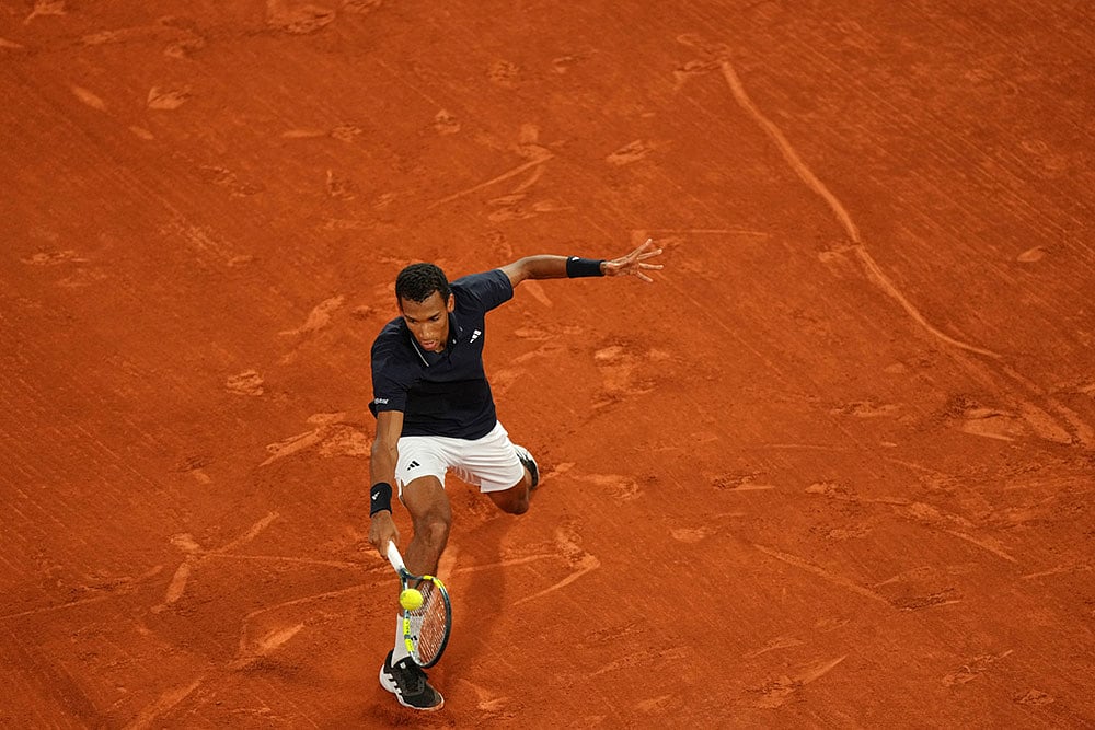 Canadas Felix Auger-Aliassime returns to Italys Flavio Cobolli during the quarterfinal tennis match at the French Open in Paris.