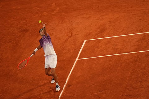 Italy's Flavio Cobolli returns to Canada's Felix Auger-Aliassime during the quarterfinal tennis match at the French Open in Paris.