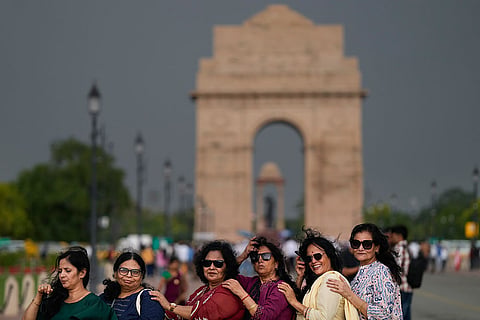 Women pose for a group picture under overcast skies, before light rain hits the city. India Meteorological Department (IMD) issued a red alert and forecasted light to moderate rain, thunderstorms and gusty winds across the city over the next few hours.