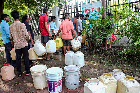 People stand in queue to fill water, as the water supply gets disrupted, after the repair of the Kolar water supply could not be completed on Thursday, in Bhopal, Madhya Pradesh.