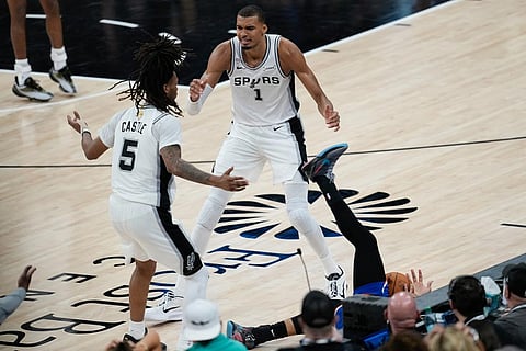 San Antonio Spurs forward Victor Wembanyama (1) and guard Stephon Castle (5) react as New York Knicks guard Jalen Brunson falls out of bounds during the second half of Game 2 of the NBA Finals basketball series in San Antonio.