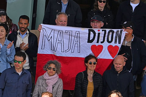 Poland's Maja Chwalinska fans holad up a flag the final tennis match against Russia's Mirra Andreeva at the French Open in Paris.