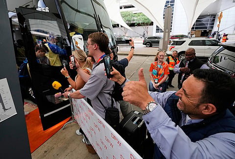 Fans wave as the Swedish men's national team boards a waiting bus after arriving at Dallas Fort Worth International Airport in DFW Airport, Texas, ahead of the World Cup soccer tournament.