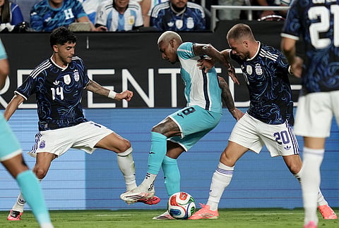 Honduras' Joseph Rosales (8) fights off Argentina midfielder Alexis Mac Allister (20) and midfielder Exequiel Palacios (14) during the second half of an international friendly soccer match in College Station, Texas.