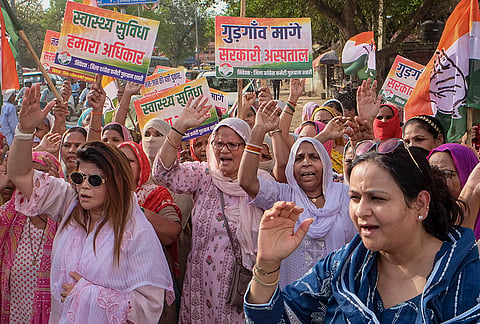 Congress workers hold placards and stage a protest against the Haryana government demanding government hospitals, in Gurugram, Haryana.