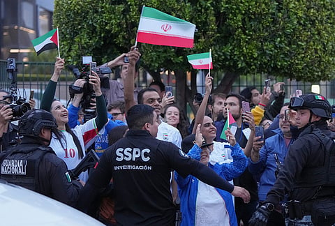 Fans for team Iran wave as players arrive for the World Cup soccer tournament in Tijuana, Mexico.