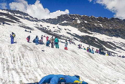 Tourists gather on a snow covered slope at Rohtang Pass, in Manali, Himachal Pradesh.