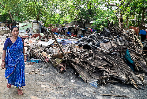 A woman passes by demolished structures after authorities carried out an eviction drive to demolish allegedly illegal shanties, shops, and encroachments near Jadavpur Railway Station, in Kolkata, West Bengal.
