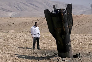 | Photo: AP/Mahmoud Illean : A man look at the wreckage of an Iranian missile that landed near the West Bank city of Jericho.
