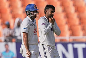 | Photo: AP/Ashwini Bhatia : Afghanistan's Rahmat Shah, left, looks on as India's Manav Suthar takes the catch to dismiss Afghanistan's Afsar Zazai off his own bowling on day two of the cricket test match between Afghanistan and India in New Chandigarh.
