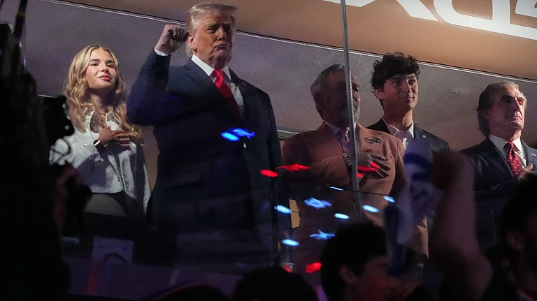 President Donald Trump gestures during the National Anthem as he attends an NBA Finals playoff basketball game between the New York Knicks and the San Antonio Spurs at Madison Square Garden in New York, Monday, June 8, 2026, with Kai Trump, left, Knicks owner James Dolan and Interior Secretary Doug Burgum, right - (AP Photo/Mark Schiefelbein)
