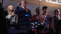 (AP Photo/Mark Schiefelbein) : President Donald Trump gestures during the National Anthem as he attends an NBA Finals playoff basketball game between the New York Knicks and the San Antonio Spurs at Madison Square Garden in New York, Monday, June 8, 2026, with Kai Trump, left, Knicks owner James Dolan and Interior Secretary Doug Burgum, right