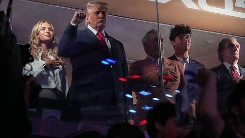 (AP Photo/Mark Schiefelbein) : President Donald Trump gestures during the National Anthem as he attends an NBA Finals playoff basketball game between the New York Knicks and the San Antonio Spurs at Madison Square Garden in New York, Monday, June 8, 2026, with Kai Trump, left, Knicks owner James Dolan and Interior Secretary Doug Burgum, right