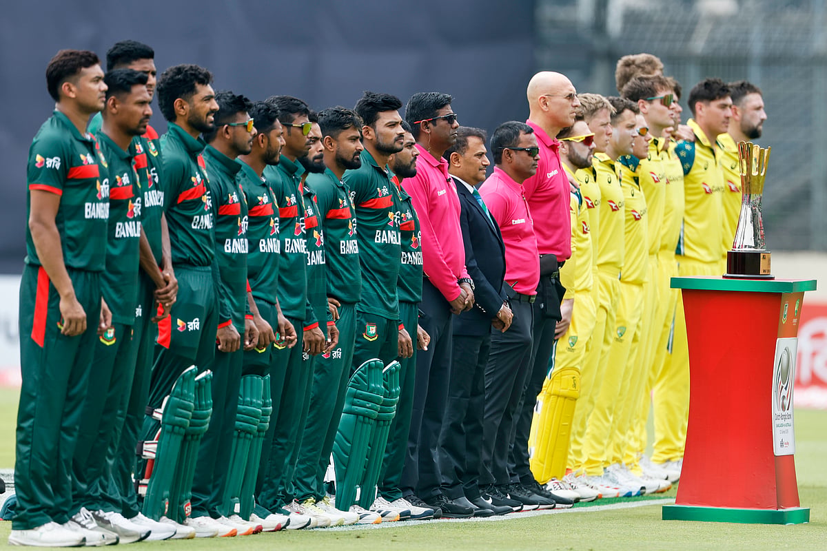 Bangladesh and Australia's players stand up for their national anthem before the start of the first one day international cricket match. - AP