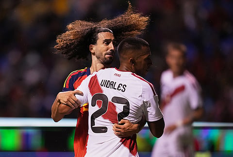 Peru's Jhonny Vidales, front, and Spain's Marc Cucurella fight for the ball during an international soccer match in Puebla, Mexico.
