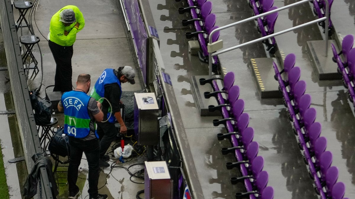 TV crews set up equipment after heavy rain before an international friendly soccer match between Costa Rica and England. - AP Photo