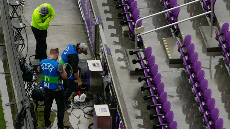 TV crews set up equipment after heavy rain before an international friendly soccer match between Costa Rica and England. - AP Photo