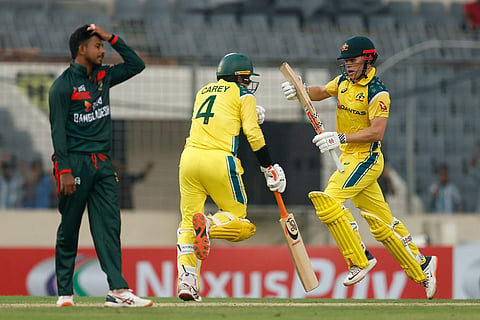 Australia's Alex Carey, left, and Cooper Connolly run between the wickets to score during the first one day international cricket match between Australia and Bangladesh in Mirpur, Bangladesh.