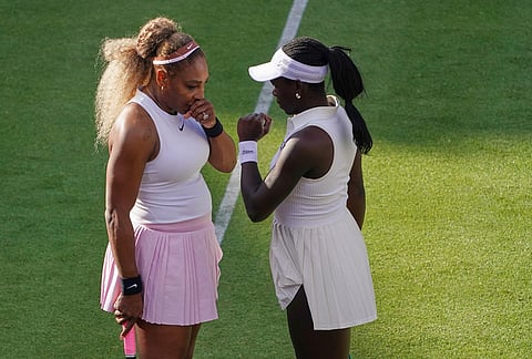 Serena Williams of the United States, left, talks to playing partner Victoria Mboko of Canada as they play against Nicole Melichar-Martinez of Canada and Erin Routliffe of New Zealand during their first round doubles match at the Queen's Club tennis championships in London