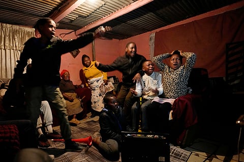 A family watches a world cup opening soccer match, in Vereeniging, South Africa, Thursday, June 11, 2026.