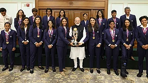 | Photo: Handout via PTI : Prime Minister Narendra Modi holding the ICC Women's Cricket World Cup winner's trophy as he poses for a photograph with the winning Indian women cricket team in New Delhi.