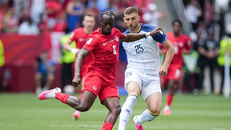 Canada's Ismael Kone (8) passes the ball while being chased by Bosnia's Jovo Lukic (25) during the first half of the World Cup Group B soccer match between Canada and Bosnia, Friday, June 12, 2026, in Toronto. - (Nathan Denette/The Canadian Press via AP)