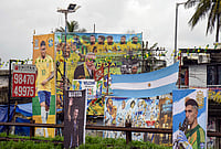 India's FIFA World Cup Paradox: A Nation Of Passionate Fans, But No Players On The Field | Photo: PTI : Football fans of various clubs install large hoardings of Brazilian player Neymar Jr, Argentine players Lionel Messi and Emiliano Martínez, football manager Lionel Scaloni and other players ahead of the FIFA World Cup, at Kochi, in Ernakulam district, Kerala.