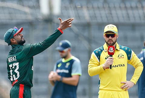 Bangladesh's captain Mehidy Hasan Miraz, left, tosses the coin for the toss as Australia's captain Josh Inglis looks during the second one day international cricket match between Australia and Bangladesh in Mirpur, Bangladesh.