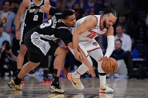 New York Knicks guard Jalen Brunson (11) and San Antonio Spurs forward Keldon Johnson (3) battle for the ball during the second half of Game 4 of the NBA Finals basketball series in New York.