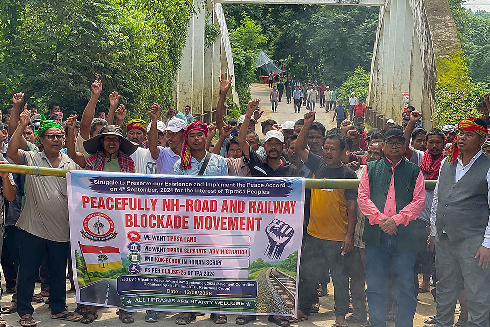 Surrendered members of the National Liberation Front of Tripura (NLFT) and All Tripura Tiger Force (ATTF) block a national highway in protest at Baramura area, near Agartala, Tripura. - | Photo: PTI
