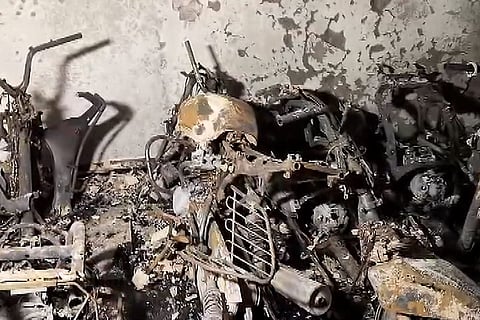Charred remains of two-wheelers and bicycles are seen after a fire broke out in a five-storey residential building at Tughlakabad Extension area, in New Delhi. At least three people were killed while two others were critically injured in the incident.