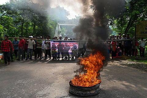 Surrendered members of the National Liberation Front of Tripura (NLFT) and All Tripura Tiger Force (ATTF) burn a tyre as they block a road in protest at Baramura area, near Agartala, Tripura.
