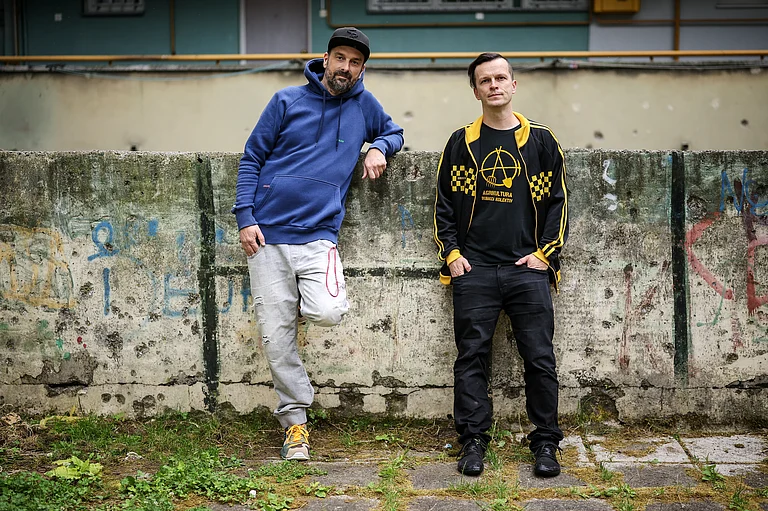 Brano Jakubovic, left, and Vedran Mujagic, members of Bosnian band Dubioza kolektiv, pose for a photo at a soccer playground where the video for the song "I Am From Bosnia, Take Me to America" was filmed, in Sarajevo, Bosnia, Thursday, June 11, 2026. - AP Photo/Armin Durgut