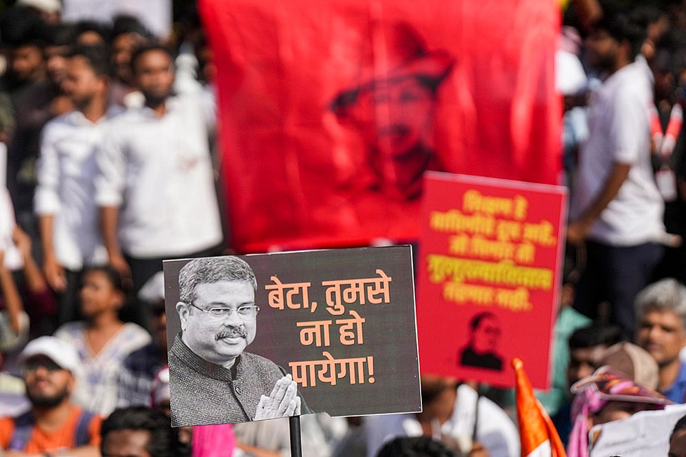 Cockroach Janta Party (CJP) supporters hold placards during a protest organised by party founder Abhijeet Dipke, demanding Union Minister Dharmendra Pradhan's resignation, at Savitribai Phule Pune University (SPPU), in Pune, Maharashtra. - | Photo: PTI/Shashank Parade