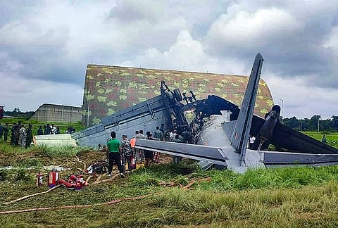 Security personnel and others stand near damaged remains of a transport aircraft of the Indian Air Force (IAF) that crashed while landing, in Jorhat district, Assam. The incident occurred while the aircraft, AN-32, belonging to 43 Squadron, carrying cargo, was landing at the IAF's airbase in the Rowriah area. 