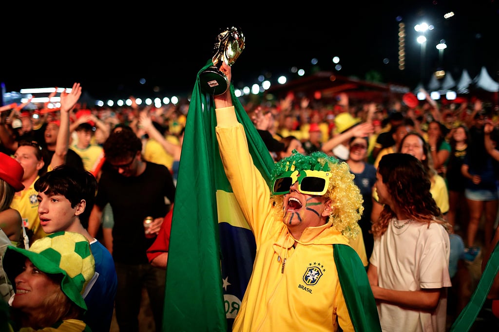 A Brazil fan celebrates before watching the World Cup match between Brazil and Morocco at Copacabana beach in Rio de Janeiro, Brazil