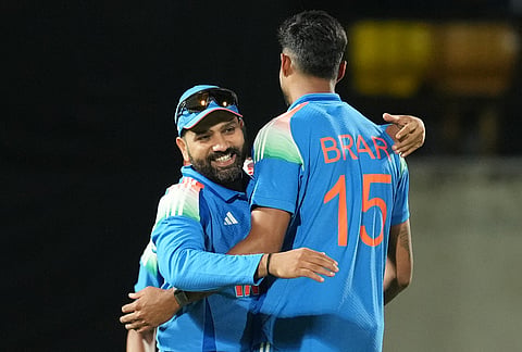 India's Rohit Sharma, left, congratulates teammate Gurnoor Brar for the wicket of Afghanistan's Rashid Khan during the first ODI cricket match between Afghanistan and India in Dharamshala.