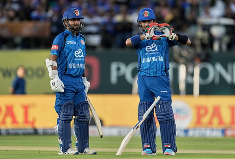 Afghanistan's Rahmanullah Gurbaz, right, celebrates his fifty runs during the first ODI cricket match between Afghanistan and India in Dharamshala.