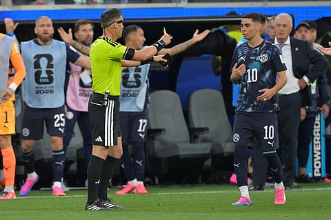 Referee Danny Makkelie issues a yellow card to Paraguay's Miguel Almiron (10) for an earlier simulation during the World Cup Group D soccer match against the United States in Inglewood, Calif., near Los Angeles, Friday, June 12, 2026.