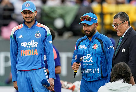 India's captain Shubman Gill, left, and Afghanistan's captain Hashmatullah Shahidi look after the coin toss ahead of the first ODI cricket match between Afghanistan and India in Dharamshala.