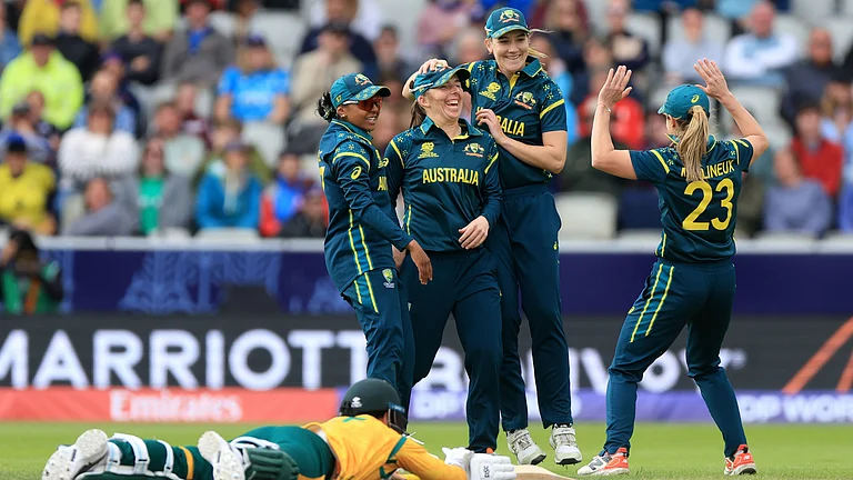 Australia's Georgia Wareham, center, celebrates with teammates after running out South Africa's Marizanne Kapp, on the ground, during the Women's T20 World Cup match between Australia and South Africa at Old Trafford, Manchester, England, Saturday June 13, 2026. - (Nigel French/PA via AP)