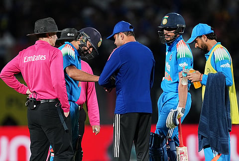 India's Rohit Sharma writhes in pain as physio checks his hand during the first ODI cricket match between Afghanistan and India in Dharamshala.
