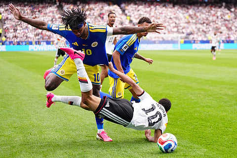 Germany's Jamal Musiala falls to the ground in a clash with Curaçao's Leandro Bacuna during the World Cup Group E soccer match between Germany and Curacao in Houston, Sunday, June 14, 2026. 